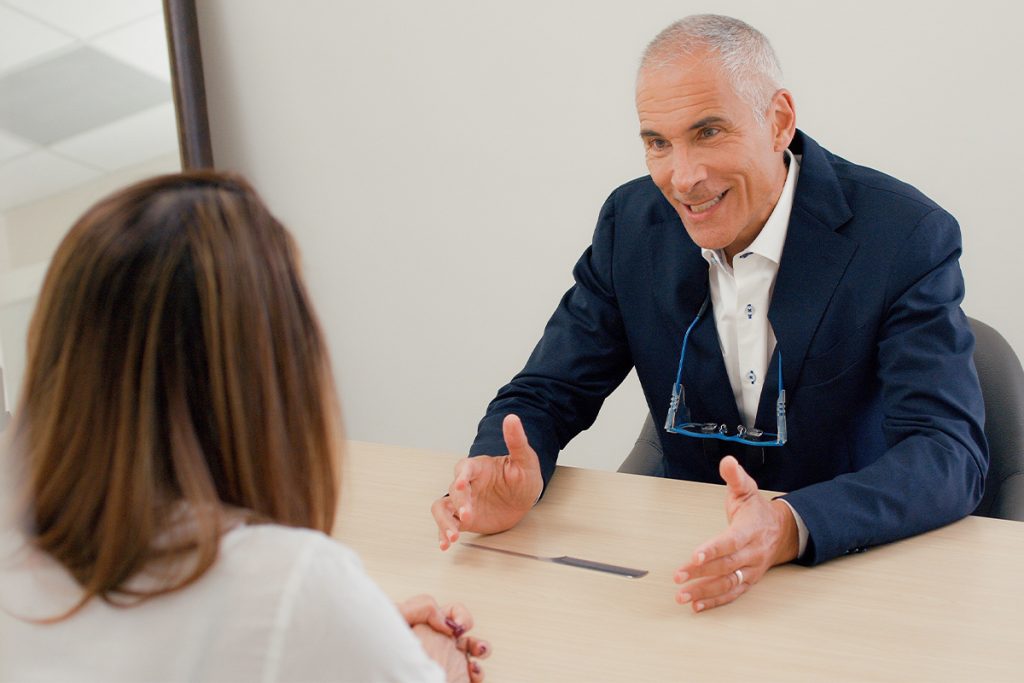 El Dr. Jeffrey Epstein, cirujano plástico facial certificado por la junta de Miami, conversa con un paciente durante una consulta individual.