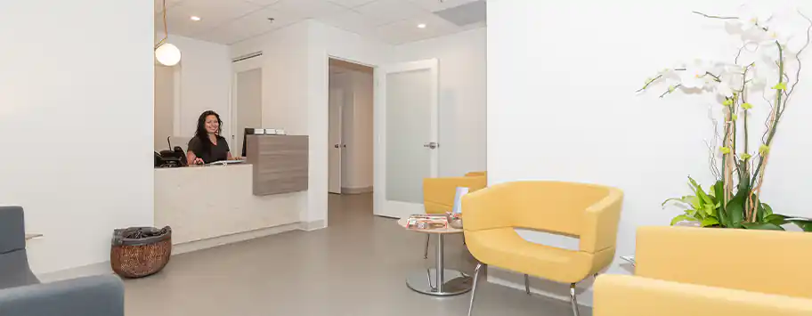 Reception area at Dr. Epstein's office with seating, a front desk, and modern décor.
