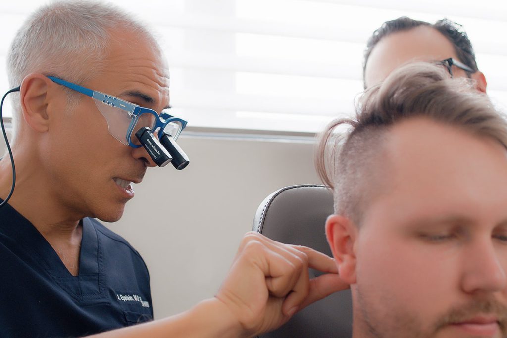 Dr. Jeffrey Epstein, Miami board-certified facial plastic surgeon, peforming hair Transplant Revision