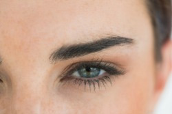 Close-up of a person's eye and eyebrow highlighting a full, well-defined eyebrow.