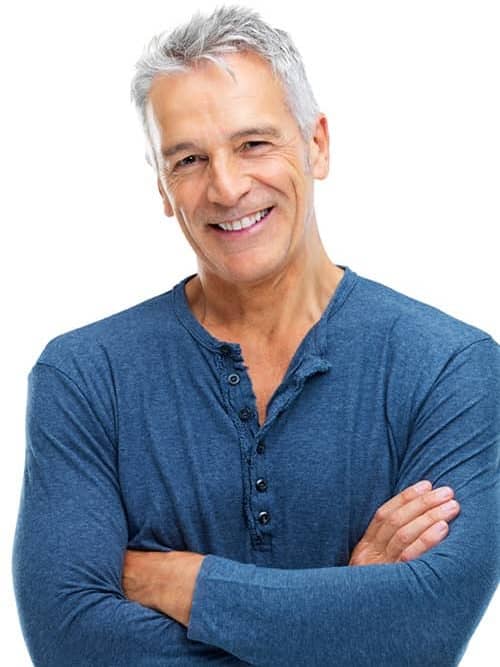 Portrait of a smiling middle-aged man with gray hair standing with his arms crossed.