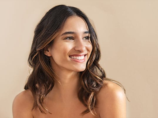 Smiling woman with shoulder-length dark hair looking to the side.