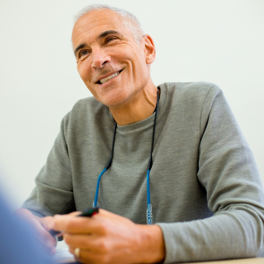 Dr. Jeffrey Epstein, Miami board-certified facial plastic surgeon, smiling during a consultation with a patient.