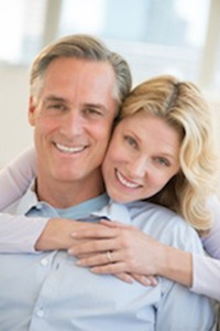 Smiling couple embracing and looking at the camera.