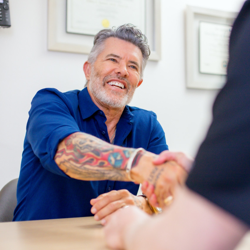 Patient shaking hands with a member of Dr. Jeffrey Epstein's team following a consultation.