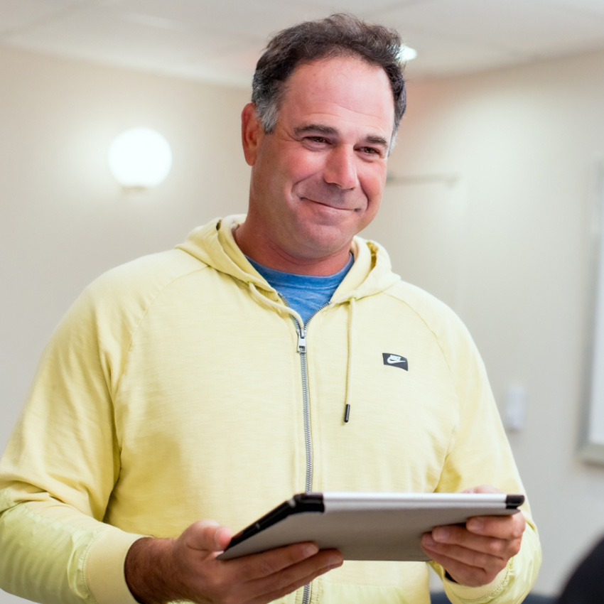 Patient holding a tablet while completing paperwork in the office.
