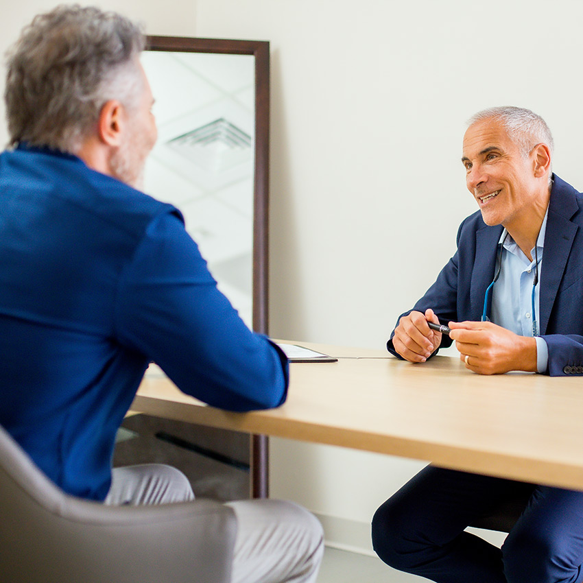 Dr. Jeffrey Epstein, Miami board-certified facial plastic surgeon, speaking with a patient during a one-on-one consultation.