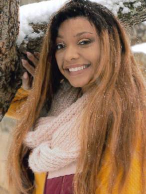 Young woman smiling outdoors after successful hair restoration treatment.