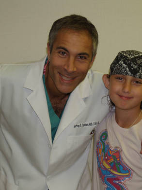 Dr. Jeffrey Epstein, Miami board-certified facial plastic surgeon, posing with a young patient before a pediatric hair restoration procedure.